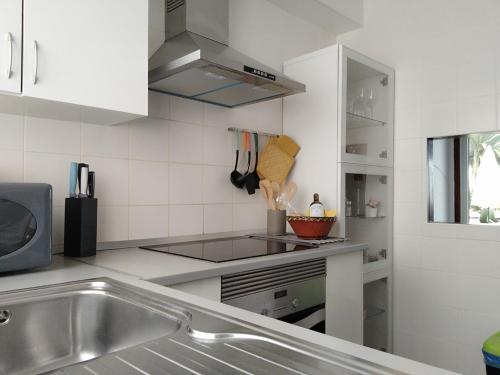 a white kitchen with a sink and a stove at House Experience Villa Violeta in La Victoria de Acentejo