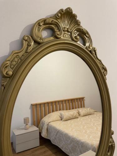 a large gold mirror in a bedroom with a bed at Cavour16 rent bedrooms in Genova
