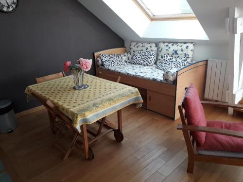 Cette chambre comprend une table, un lit et un canapé. dans l'établissement Appartement vue mer avec piscine intérieure, à Larmor-Plage