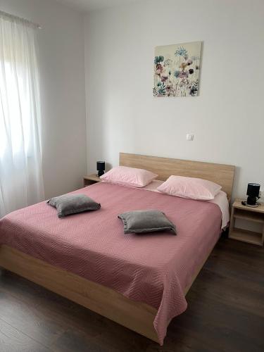 a bedroom with a large bed with two pillows at Apartment Sanja in Zadar