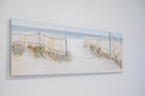 a painting of a fence on a beach at Hillcrest Studio Apartments in Cleethorpes