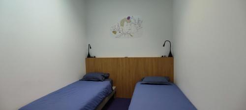 a room with two beds and a clock on the wall at BARTHOME in Taissy