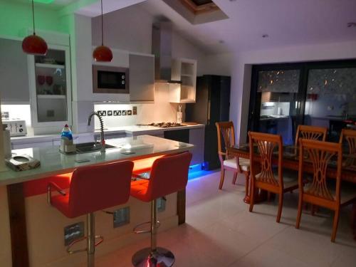 a kitchen and dining room with a counter and chairs at Luxury holiday home, near beach in Southend-on-Sea