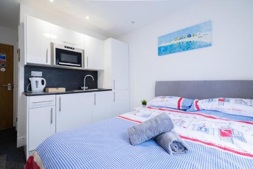 a bedroom with a bed and a microwave above it at Hillcrest Studio Apartments in Cleethorpes