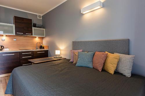 a bedroom with a large bed with colorful pillows at VacationClub - Bryza 7 Apartament 5 in Świnoujście