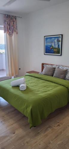 a large green bed with a green blanket on it at Vallessa Vip in Vinkuran