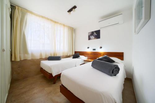 a hotel room with two beds and a window at Apartamentos Tamara in Maspalomas