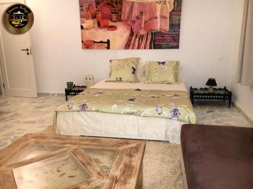 1 dormitorio con 1 cama y reloj en la pared en Suite Aurora Villa Naïa Domaine Béluga en Sidi el Moujahed