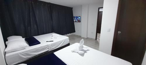 a small bedroom with two beds and a mirror at Hotel Caldas Real in Caldas