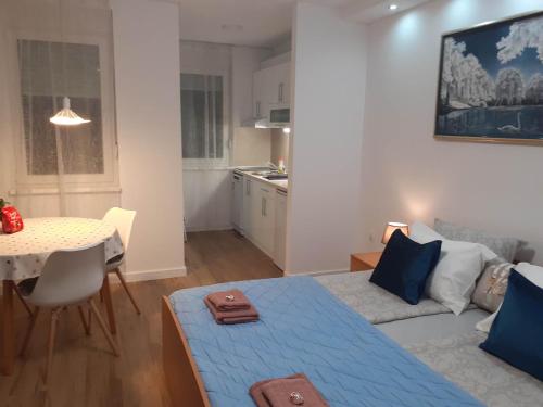 a living room with a blue bed and a table at Apartments Biro in Subotica