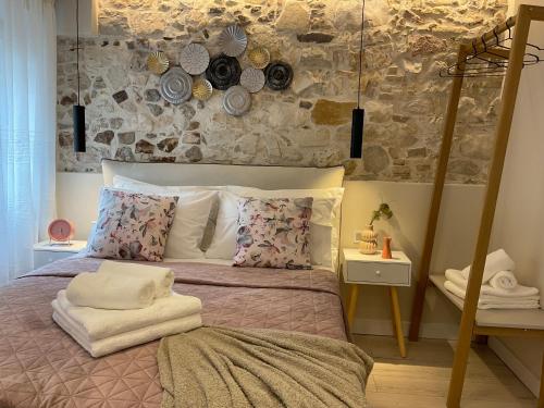 a bedroom with a bed and a stone wall at Biscoutsis old town studio in Corfu
