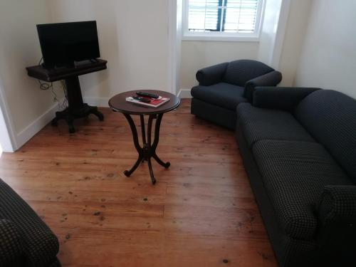 a living room with a couch and a table and a television at A Casa da Matriz in Madalena