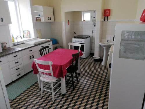 a kitchen with a table with a red table cloth on it at A Casa da Matriz in Madalena