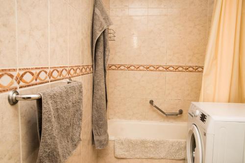 a bathroom with a tub and a washing machine at Best centric location for stay LA81 in Arona