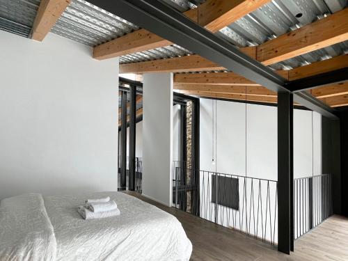 een slaapkamer met een bed en houten plafonds bij villa en el penedès in Gornal