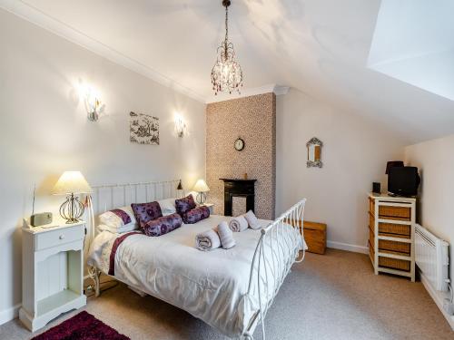 een slaapkamer met een wit bed in een kamer bij Dotty Cottage in Ellingham