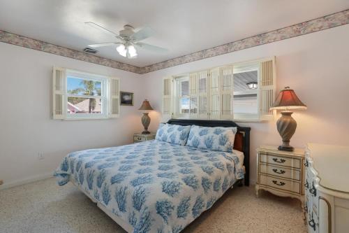 a bedroom with a bed and two windows at Ugly Tuna Down home in Anna Maria