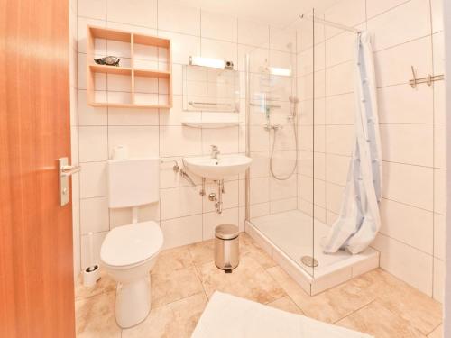 uma casa de banho com um WC, um chuveiro e um lavatório. em Urbane Holiday Home in Nesselwang-Reichenbach near Lake em Bayerstetten
