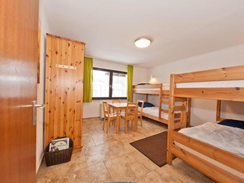 een kamer met 2 stapelbedden en een tafel bij Urbane Holiday Home in Nesselwang-Reichenbach near Lake in Bayerstetten
