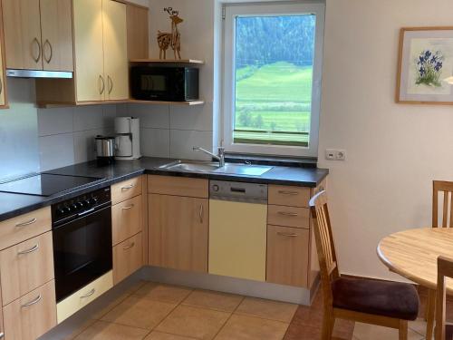 a kitchen with a sink and a table and a window at Chalet in Mittersill near Ski Lift in Mittersill