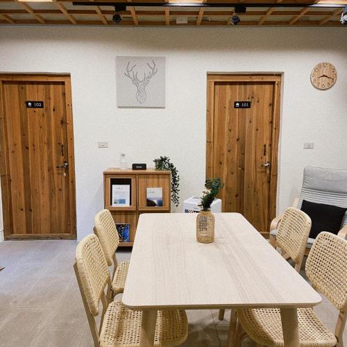 una mesa y sillas en una habitación con puertas de madera en 小島上二館, en Chung-liu-ts'un