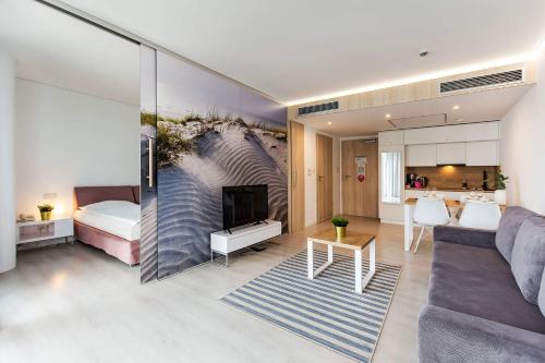 ein Wohnzimmer mit einem Sofa und ein Wohnzimmer mit einem Kamin in der Unterkunft VacationClub - Ultra Marine Apartment 36 in Kołobrzeg