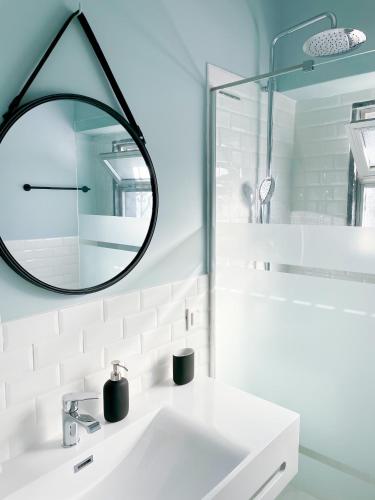 a bathroom with a white sink and a mirror at Central Olhão Home - Private Spacious Sunlit Patio in Olhão
