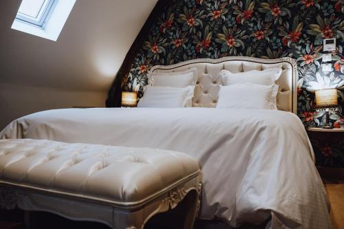 a bedroom with a white bed with a floral wall at Château Ecrin de Lumière in Campsegret