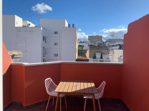 una mesa y sillas en un balcón con vistas en Rosamar Las Canteras Áticos con terraza, en Las Palmas de Gran Canaria