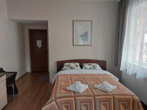 1 dormitorio con 1 cama con 2 toallas en Къща за гости Хриси, en Velingrad