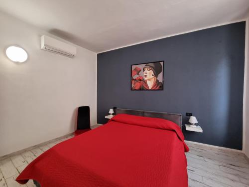 ein Schlafzimmer mit einem roten Bett mit einem Gemälde an der Wand in der Unterkunft Solino House in Capoliveri