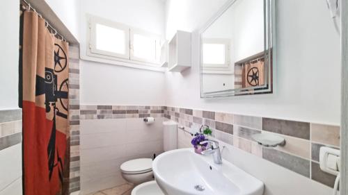 a bathroom with a sink and a toilet and a mirror at Casa Iris in Capoliveri