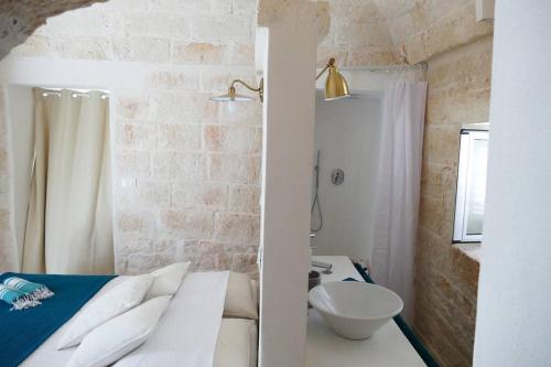 La salle de bains est pourvue d'un lit, d'une douche et de toilettes. dans l'établissement Trullo FICOLI, à Ostuni