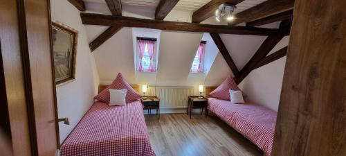 two beds in a room with two windows at Apartment am Zolltor in Wertheim