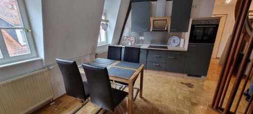 Apartment am Zolltor في فيرتهايم: مطبخ صغير فيه طاولة وكراسي