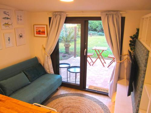 un soggiorno con divano e porta scorrevole in vetro di Cozy Suite&Lodge Mondello beach a Palermo