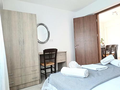 a bedroom with two beds and a desk and a mirror at Petrino Studios in Keramotí