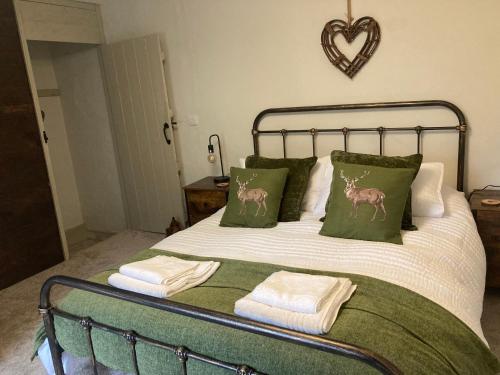 een bed met groene en witte lakens en groene kussens bij Willow Cottage in Middleton in Teesdale