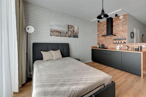 格但斯克的住宿－Grand Apartments - Studio Wałowa 2 apartment in the center of Gdańsk，一间卧室设有一张床和砖墙