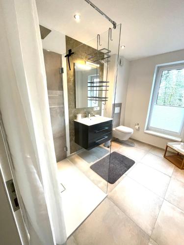 a bathroom with a sink and a toilet and a mirror at Maison du Port in Timmendorfer Strand
