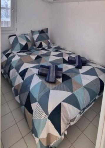 une chambre avec un lit avec une couette noire et blanche dans l'établissement Agréable T2 à La Grande Motte, à La Grande Motte