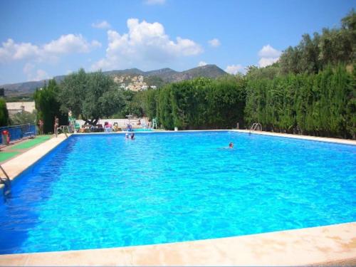 una gran piscina azul con gente en el agua en Costa Blanca belle maison entre mer et montagne, en Adsubia