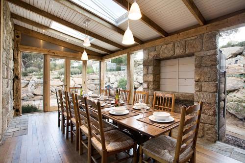 a dining room with a wooden table and chairs at The Barn by Tinkersfield in Crackenback