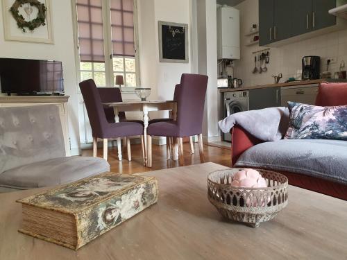 a living room with a couch and a table with chairs at L'appart d'à coté, 2 chambres in Sarlat-la-Canéda