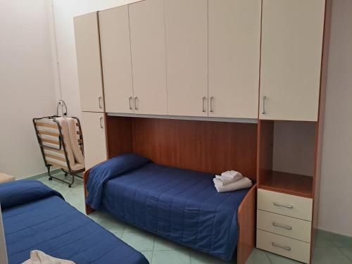 1 dormitorio con 1 cama azul y armarios blancos en La Casa Di Checco, en Santa Maria di Castellabate