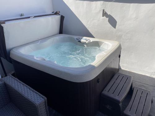 a large bath tub with a bench in front of it at Quirky cottage in the centre of Penrith with a Hot Tub in Penrith