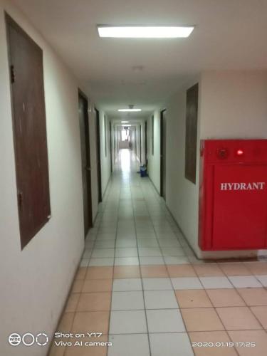 an empty hallway in a building with a red door at Eastpark Apartment in Jakarta