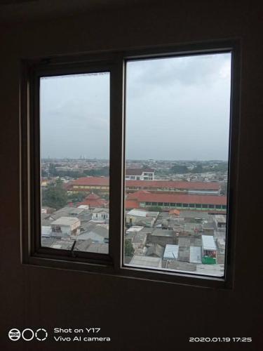 two windows in a room with a view of a city at Eastpark Apartment in Jakarta