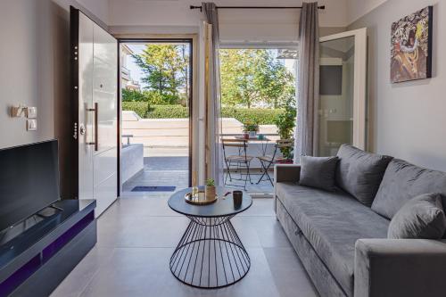 uma sala de estar com um sofá e uma mesa em Theo's Cozy Apartment near Athens airport em Spata