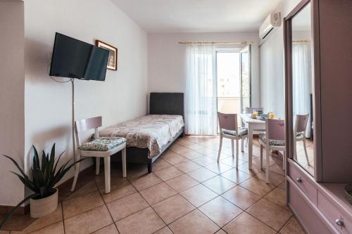 une chambre d'hôtel avec un lit, une table et une télévision dans l'établissement Villa Porta, à Biograd na Moru
